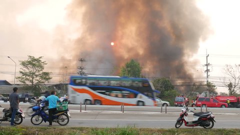 Lamphun, Thailand - April 9, 2016: During the morning Fire warehouse, causing a large flame and smoke in the air is very hot days. Firemen rush to help prevent the spread of fire , In Thailand.
