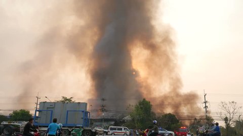 Lamphun, Thailand - April 9, 2016: During the morning Fire warehouse, causing a large flame and smoke in the air is very hot days. Firemen rush to help prevent the spread of fire , In Thailand.
