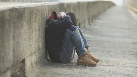 dramatic portrait of a little homeless boy on the bridge, poverty, city, street