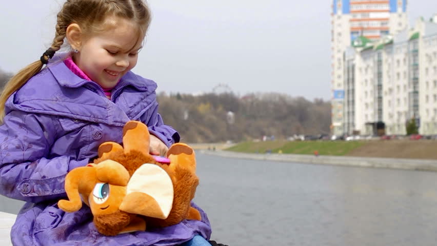 Girl combing stuffed toy elephant,
