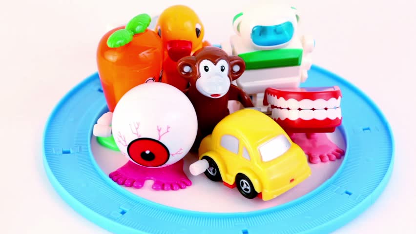 Light blue toy transport rides on circle road many times, several playthings stand in the middle