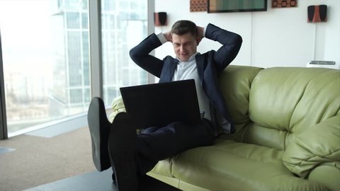 Businessman sitting at laptop and is very emotionally celebrates victory