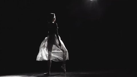 Slow motion shot of a beautiful female ballet dancer on a black background