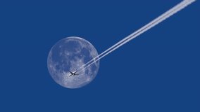 Distant airliner flying with contrail against full moon. 4K telephoto footage - Powered by Shutterstock - Get 15% off with code: PIKWIZARD15