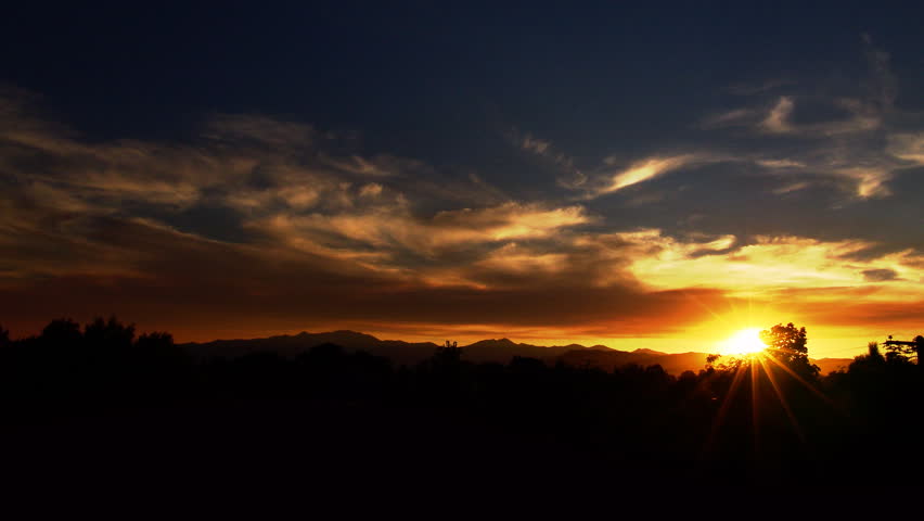 A beautiful time lapse of a sunset along a mountain range.