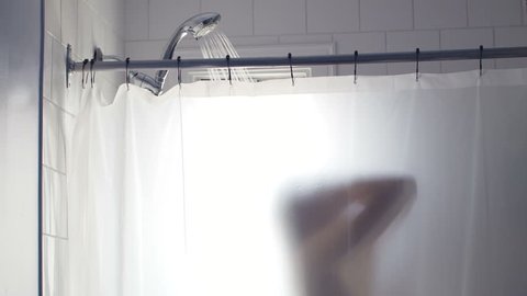Showering Woman Silhouette Blurred by the Transparent Curtain