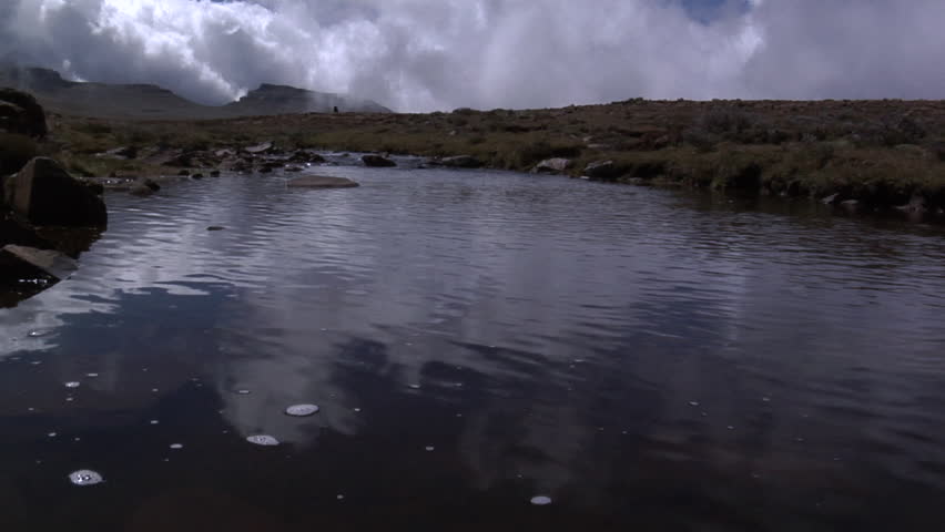 Locked off shot of a river under a stormy sky
