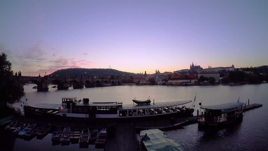 Czech Republic. Prague. The view of the Prague Castle and Vltava river. Sunset. Pleasure boats and night lights. Time lapse