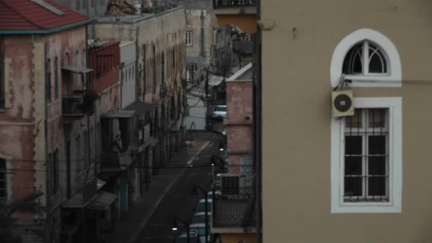 Traffic passes down a narrow street in Haifa, Israel.