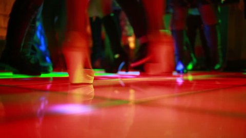 Colorful led dance floor with people dancing.