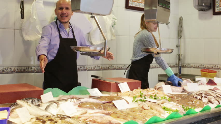 Portrait of two sellers in fish section of supermarket