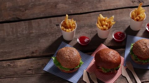 Set of burgers with fries. Cutlery and hamburgers on table. Burgers on old wooden background. Best burgers at retro diner.