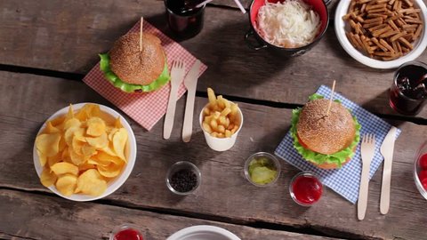 French fries and cherry tomatoes. Fries on brown wooden table. Junk food with different sauces. Retro diner table with food.