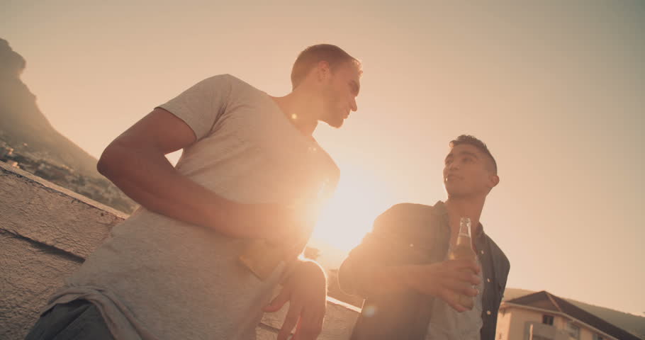 Two young men toasting with beer and enjoys a summer rooftop party | Shutterstock HD Video #15814636