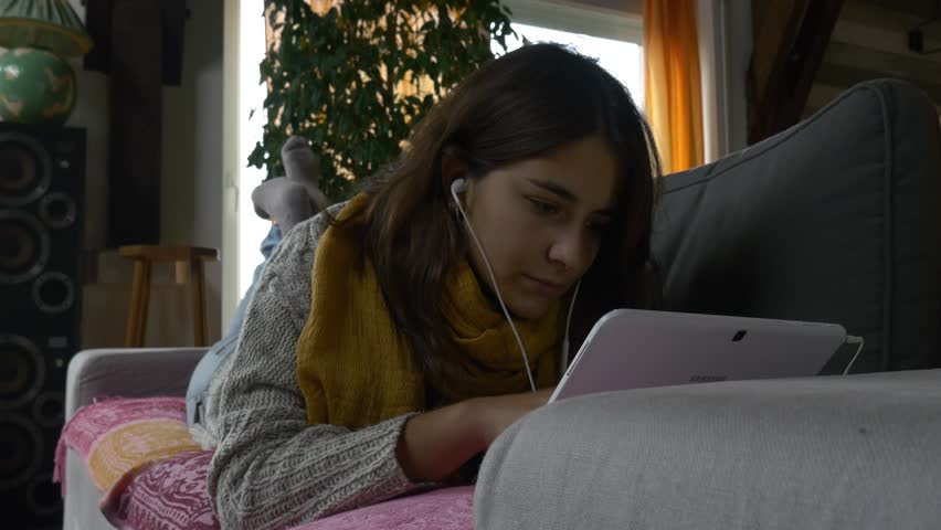 young attractive woman using tablet pc ipad 4k in beautiful countryside rural house inside rustic style modern girl hipster slider tracking shot sitting in sofa smiling close up portrait lying down