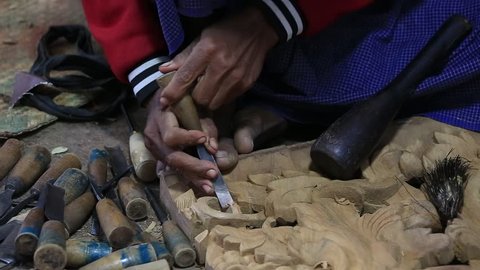 MANDALAY, MYANMAR - JANUARY 17, 2016 : Burmese man are making wooden souvenirs for tourists. Wood Carving is a traditional handicraft in Myanmar