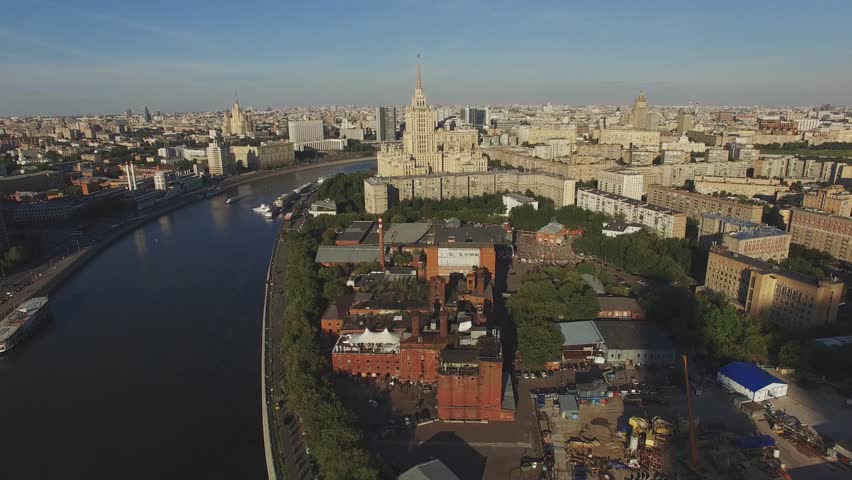 Quadrocopter fly over Moscow city in summer cloudless day. Modern and old edifices. Building of Hotel. Moscow river