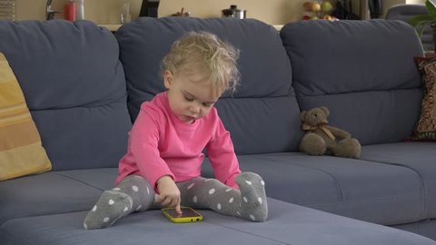 hysterical baby girl cry using smart phone on sofa. Child show negative emotions. Static closeup shot.