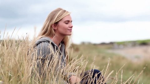 Blonde woman relaxing in the dunes in cinemagraph style