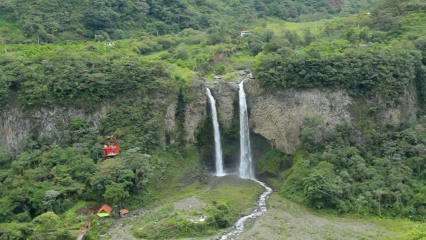 Twin waterfall in Ecuador, tourists passing by in a cable car.