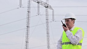Worker control transmission line ; Supervising engineer for electrification using walkie- talkies near the transmission line,video clip