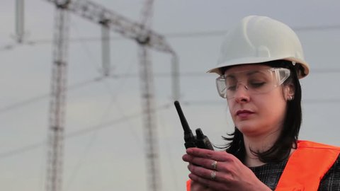 Female engineer for high voltage ; Supervising female engineer for electrification using walkie- talkies near the transmission line,video clip
