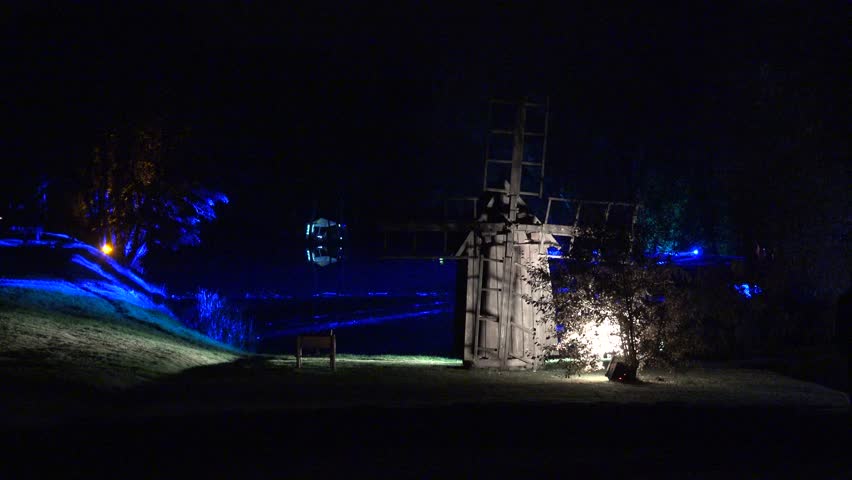 old illuminated wooden mill in lighting festival at night. Static shot. 4K