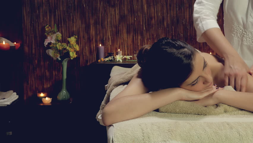 Dolly shot of woman getting back massage in spa 4K closeup retro style lookin