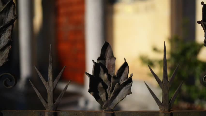 Forged metal fence around Basilica of St. Euphemia - portico with three arches that repeat mosaic frescoes by Luigi Cavenaghi, in centre of Milan, Italy. Milan the second-most populous city in Italy.