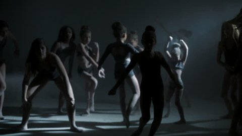 modern dance multi ethnic young girls dancing studio barefoot leotard silhouette edgy black powder performance spot light