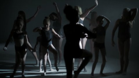 multi ethnic group female freestyle dancer dancing barefoot black leotard silhouette spot light powder flexible choreography