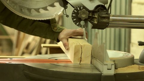 Circular saw cutting wood in carpenter workshop