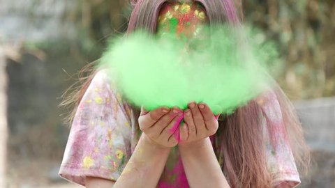 Woman blows off the paint from her palms directly into the camera. Slow motion Video Stok