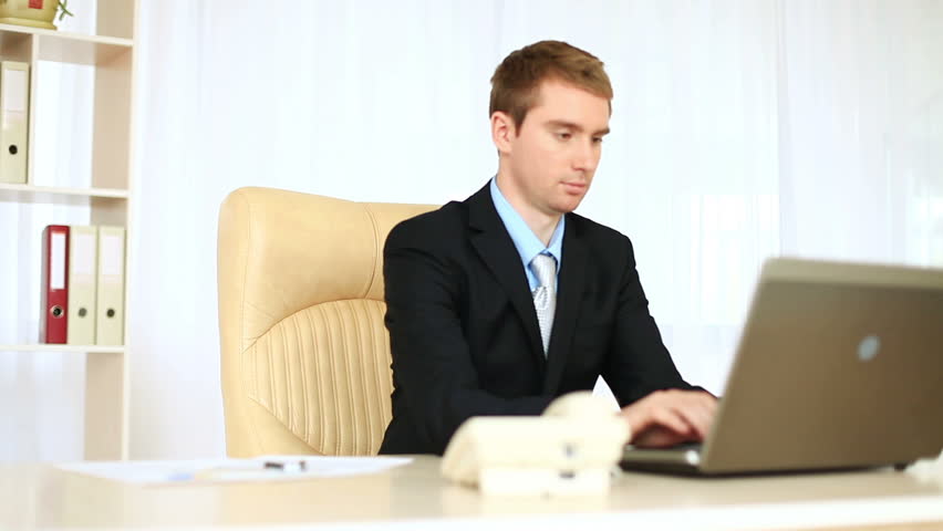 Businessman working in office looking at camera. DOLLY HD 
