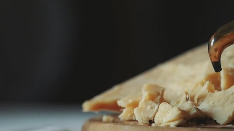 Modena balsamic vinegar poured on the famous hard cheese Parmigiano Reggiano in slowmotion.