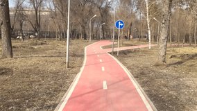 Bicycle path in the park. Almaty Central Park. Kazakhstan. People go on the track.