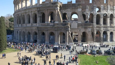 ROME, ITALY / OCTOBER 3RD 2015: Roman Coliseum colosseum on summer day with blue sky. Famous Italian landmark travel icon in the Roman forum time lapse timelapse with tourists and visitors