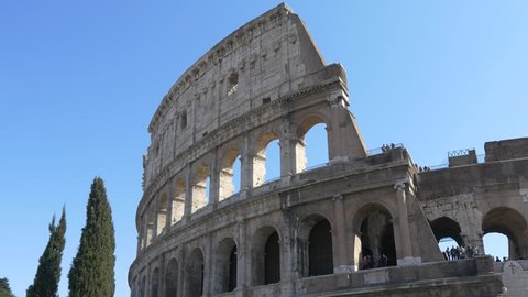 ROME, ITALY / OCTOBER 3RD 2015: Roman Coliseum colosseum on summer day with blue sky. Famous Italian landmark travel icon in the Roman forum  with tourists and visitors