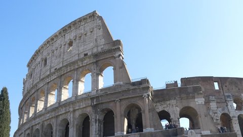 ROME, ITALY / OCTOBER 3RD 2015: Roman Coliseum colosseum on summer day with blue sky. Famous Italian landmark travel icon in the Roman forum  with tourists and visitors