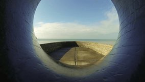 Video footage of the sea in a sunny day from the hole of a monument in the seaside of Brighton, Uk.