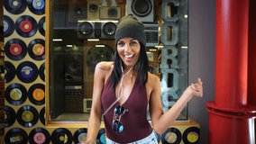 America - January 2016: America - January 2016: Mall music dance Ethnic happy Hispanic Hipster aviator sunglasses female record shop lifestyle casual ear buds jeans