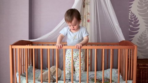 Baby Boy Standing in His Crib, Pushes the Blanket in Her Crib, She Begins to Jump in His Bed, and to Loosen it