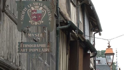 HONFLEUR/FRANCE 28TH AUGUST 2010: Old street lamp and shop sign blowing in the wind in Honfleur France