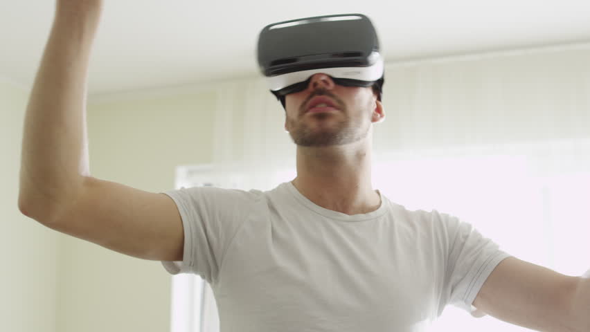 Man Wearing VR Headset at Living Room. Using Gestures with Hands. Shot on RED Cinema Camera. Royalty-Free Stock Footage #15906697