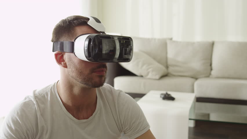 Man Wearing VR Headset at Living Room. Using Gestures with Hands.Shot on RED Cinema Camera. Royalty-Free Stock Footage #15906700