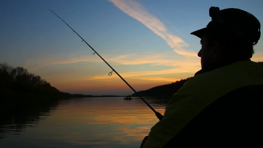 man fishes with spinning at sunset 