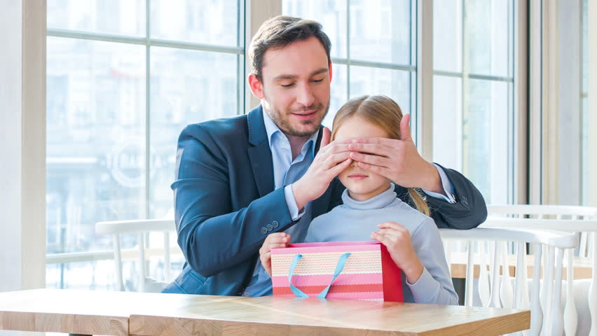 Positive father and his daughter sitting in the cafe