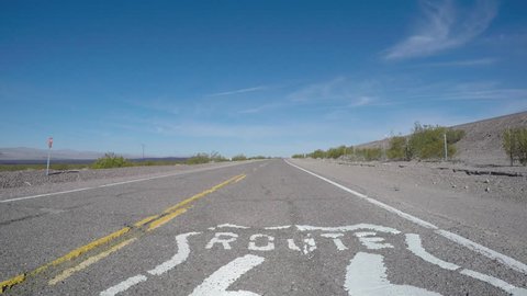 Route 66 old rustic pavement sign driving shot near Barstow, California.