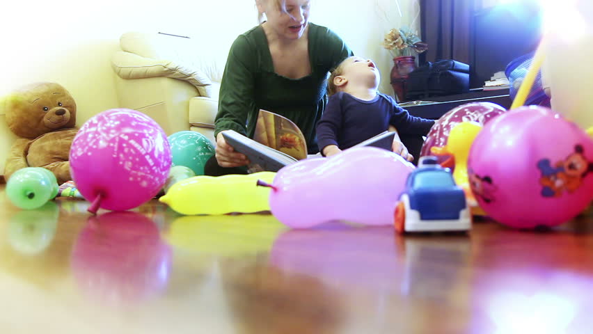 Mother and baby boy playing, surrounded by toys
