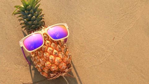pineapple in sunglasses on sand beach. Arkivvideo